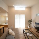 勾配天井の開口からこぼれる陽光が、漆喰壁とオークの床を優しく照らして