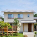 洗い出し仕上げと鎖樋が調和し、印象的な玄関ポーチ