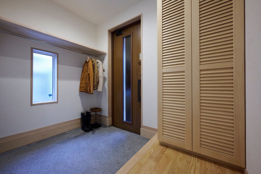 洗い出し仕上げの広い玄関土間には、多目的に使えるポールを