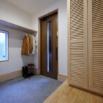 洗い出し仕上げの広い玄関土間には、多目的に使えるポールを