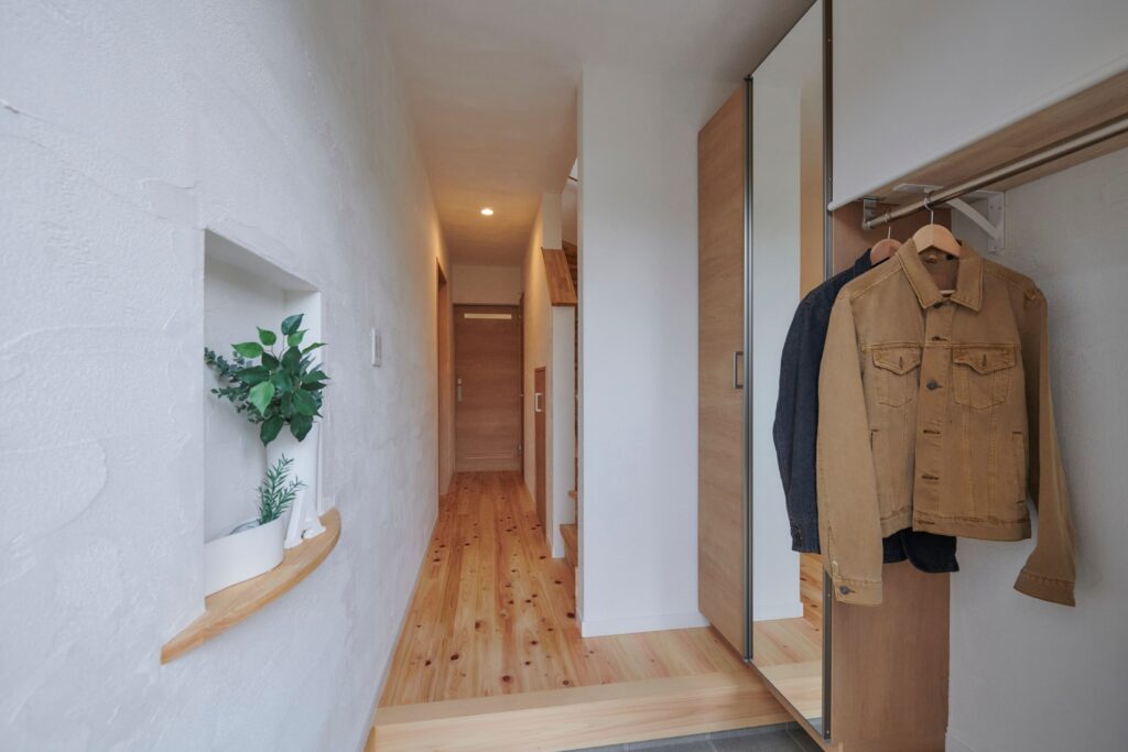 さりげなく弧にデザインしたニッチ　ロールスクリーンを施したコート掛け<br />
