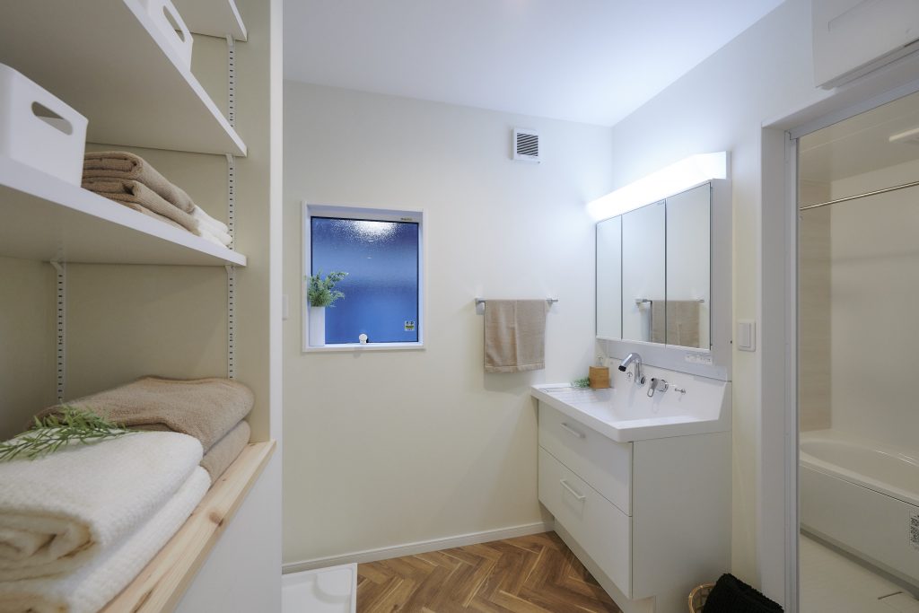 タオルなどを収納できる可動棚を設けた洗面脱衣室<br />
