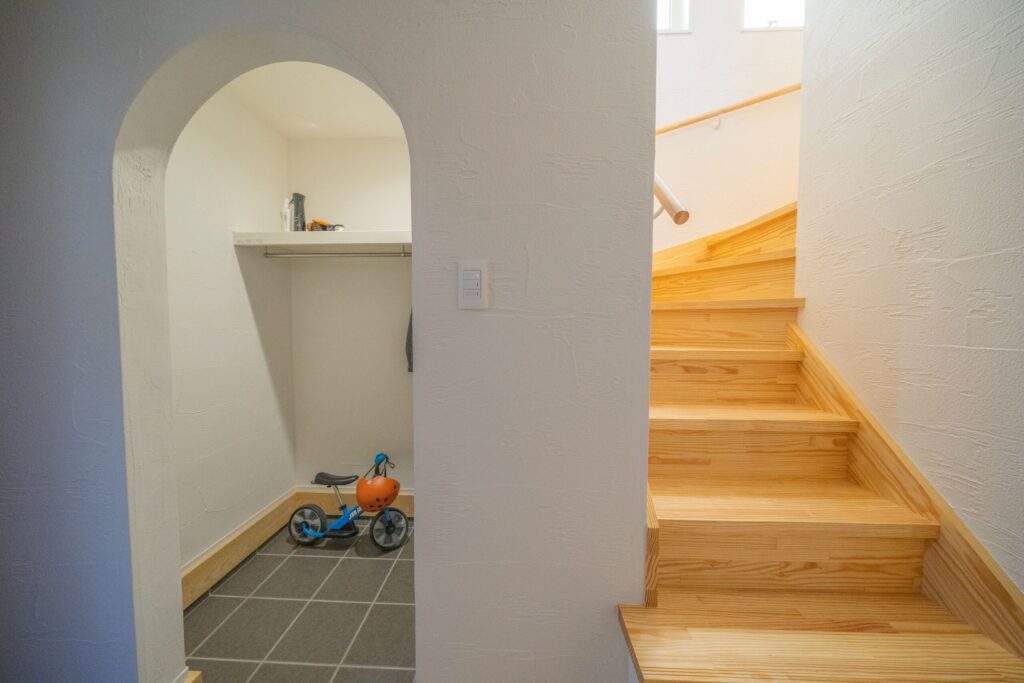 子世帯の玄関　アーチの下がり壁が、シューズインクロークと空間をやさしく分けます