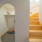子世帯の玄関　アーチの下がり壁が、シューズインクロークと空間をやさしく分けます