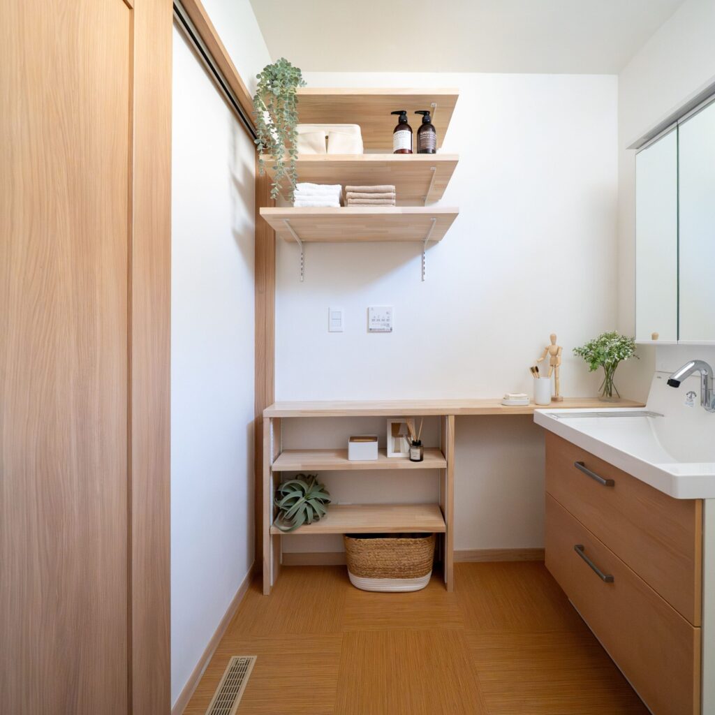 システム洗面台の使いやすさに、木の造作棚のぬくもりを重ねて