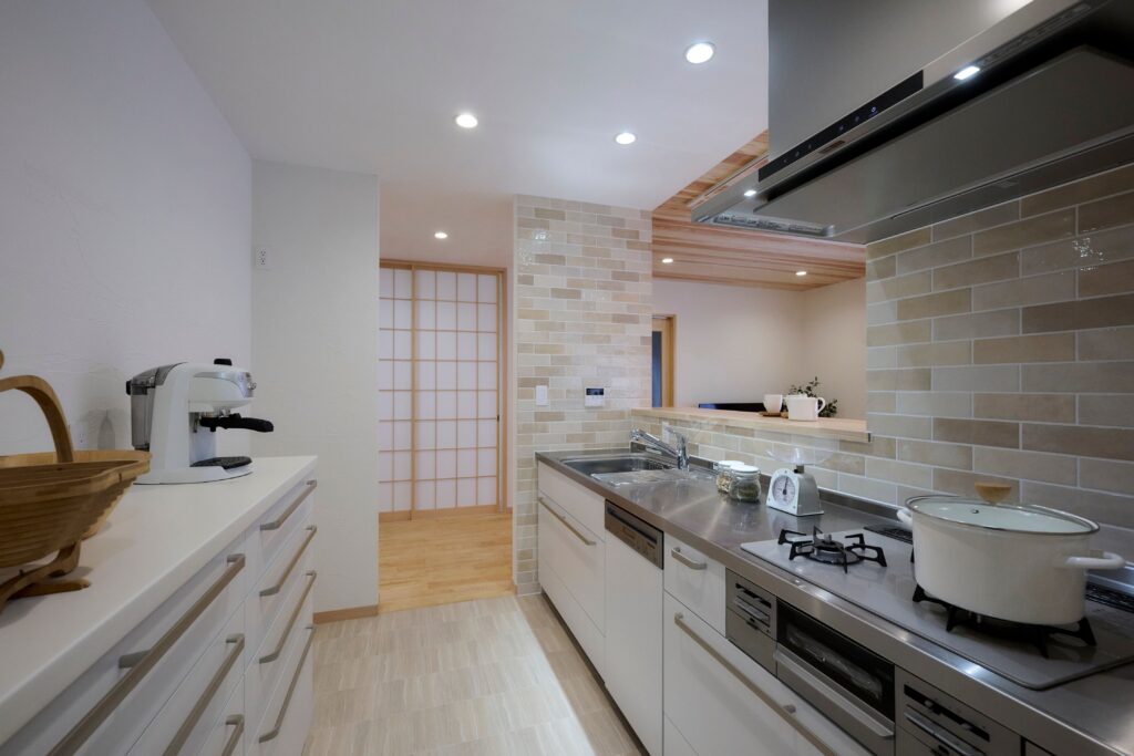 清潔感あふれる白のキッチンには、自然素材に似合う色のタイルをあわせて