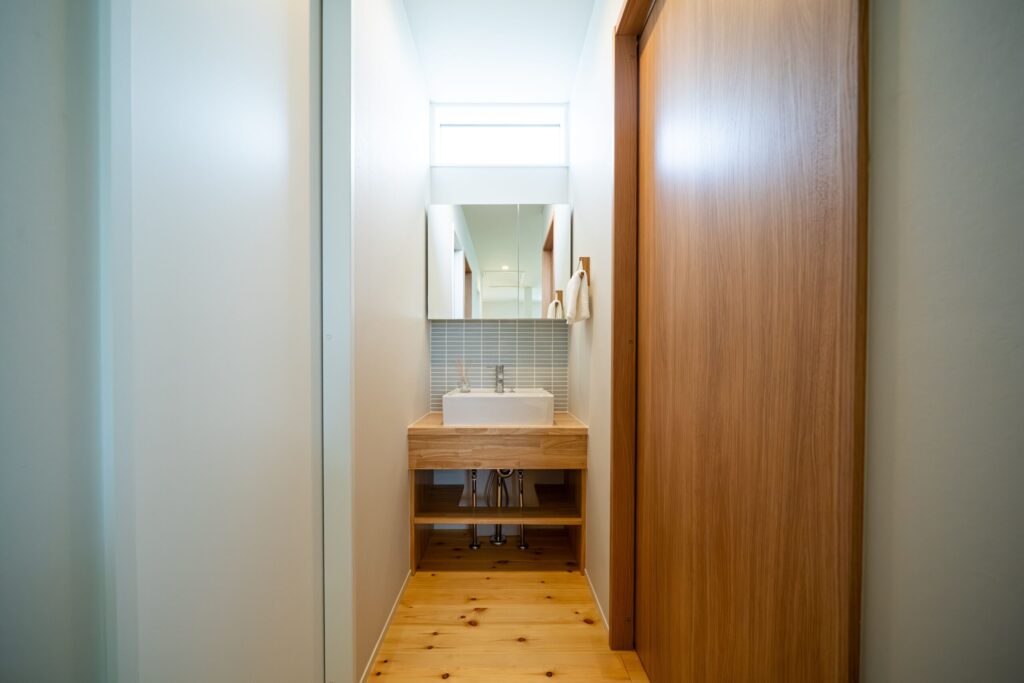 プライベートな洗面スペース　柔らかな色合いのタイルと木の温もりの癒し