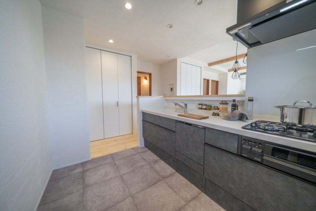 グレーブラックのキッチン＋モルタル調の床　トレンド感あふれる空間