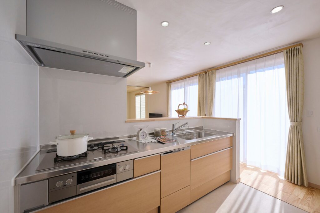 天然木の色に揃えたシンプルな設えのシステムキッチン