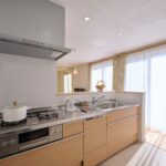 天然木の色に揃えたシンプルな設えのシステムキッチン