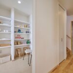 キッチン横のパントリー　回遊動線の先に見えるのはランドリールームの収納