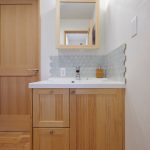 タイルのアクセントが映える木製洗面化粧台
