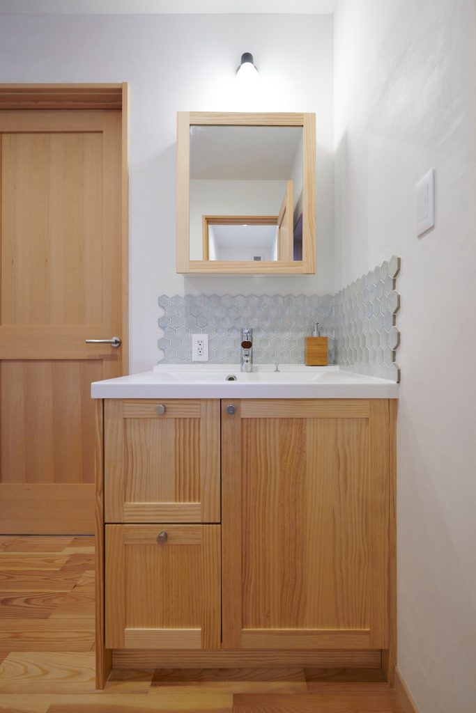 タイルのアクセントが映える木製洗面化粧台<br />
