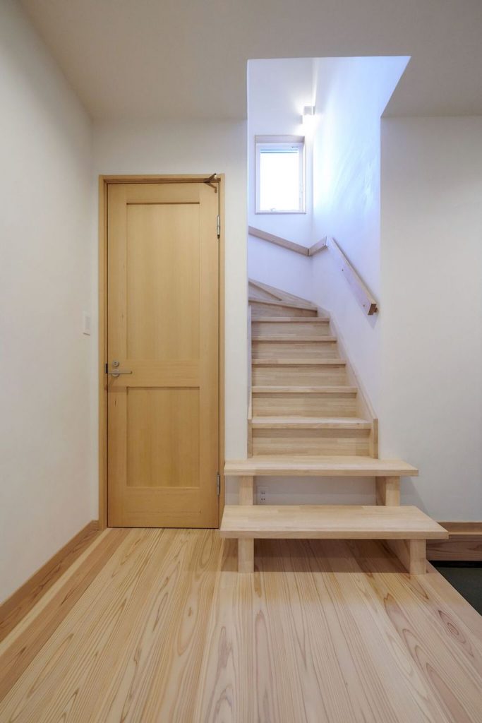 明るい陽射しが差し込む階段には、使う度に愛着がわく無垢材の手摺をつけました。<br />
スケルトン部分にはルンバの基地があります。