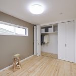 大きなクローゼットを持つ主寝室はニュアンスカラーの壁紙+パイン無垢床がやさしい印象に