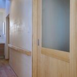 天窓からの陽光が明るい洗面台、建具に合わせた握りやすい天然木の手摺は、お母様を想う設えに