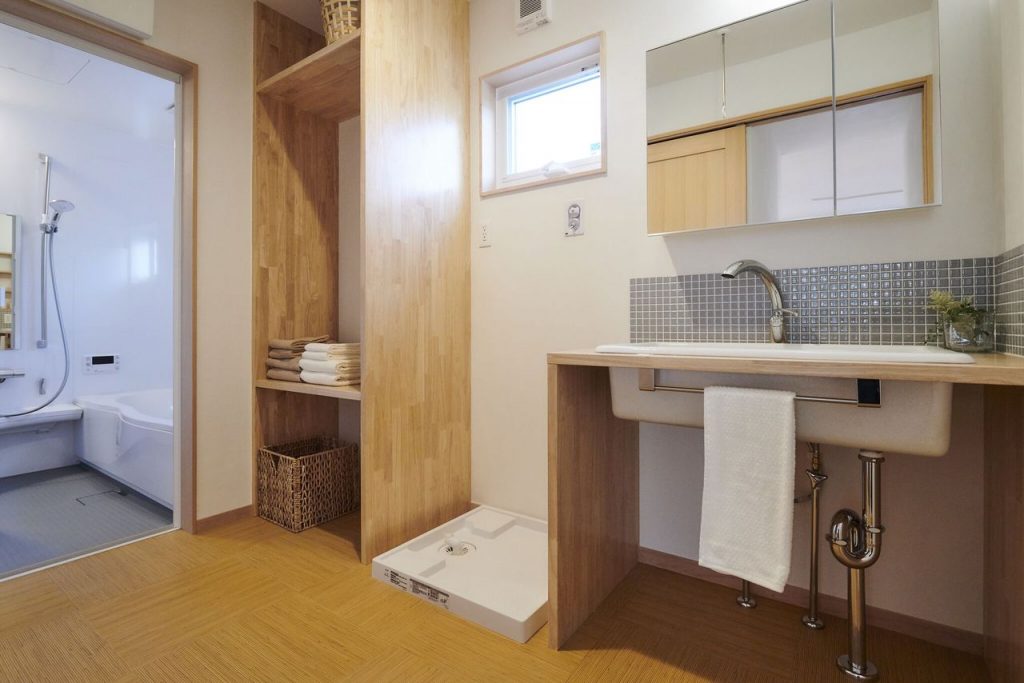 大きな洗面脱衣室には、実験用シンクを使った洗面化粧台やリネン棚を設えました。<br />
床には、足触りが良い籐タイルを使っています。