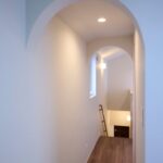 さりげなく設けた2つのアーチ壁が、空間を優しく分けて