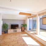 リビングから外部へと続く壁面をグレーのスタッコフレックスで仕上げ、空間に広がりを持たせました　
バルコニーに斜めに配置したフェンスが光と風を取り込みプライベートを守ります